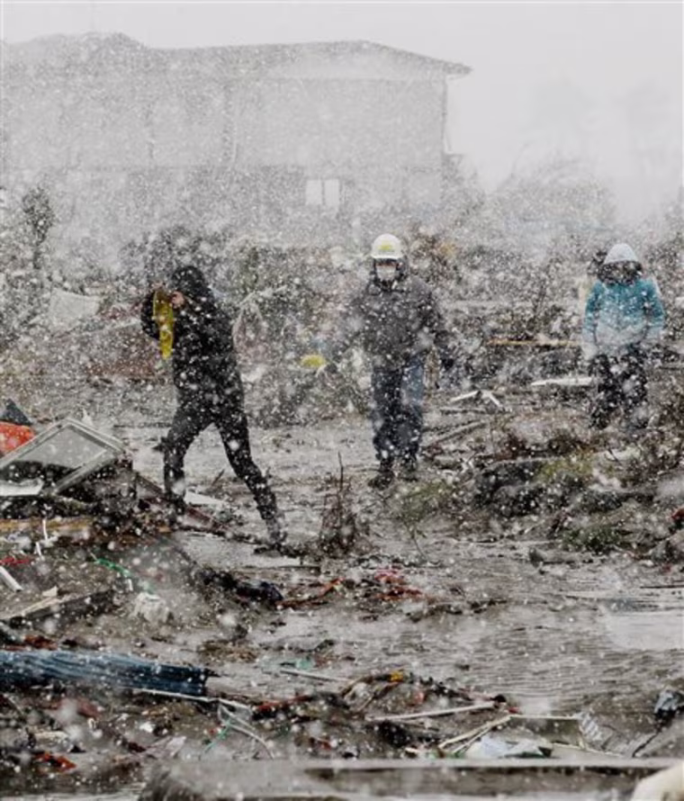Braving falling snow, residents return to a place where their home used to be to search for household goods Wednesday March 16, 2011 in Sendai, Miyagi prefecture, Japan. (AP Photo/Kyodo News) JAPAN OUT, MANDATORY CREDIT, NO LICENSING IN CHINA, HONG KONG, JAPAN, SOUTH KOREA AND FRANCE